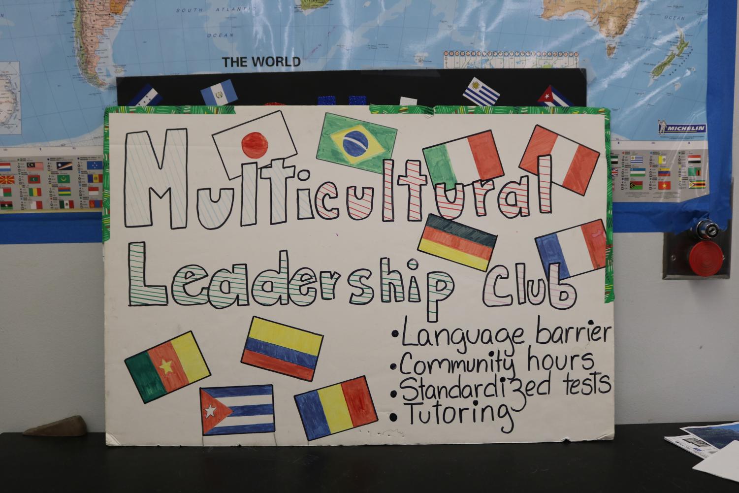 A sign hangs on Mr.Rodriguezs board encouraging people to join multicultural club for its benefits. He wants people of different lorigins to be able to help each other in tutoring and English skills.
