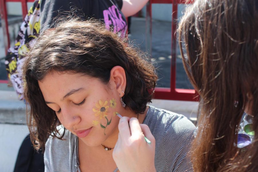 Kaylee Ramos painting the face of Fiona Kelly. An event that took place during lunch for Art Week.