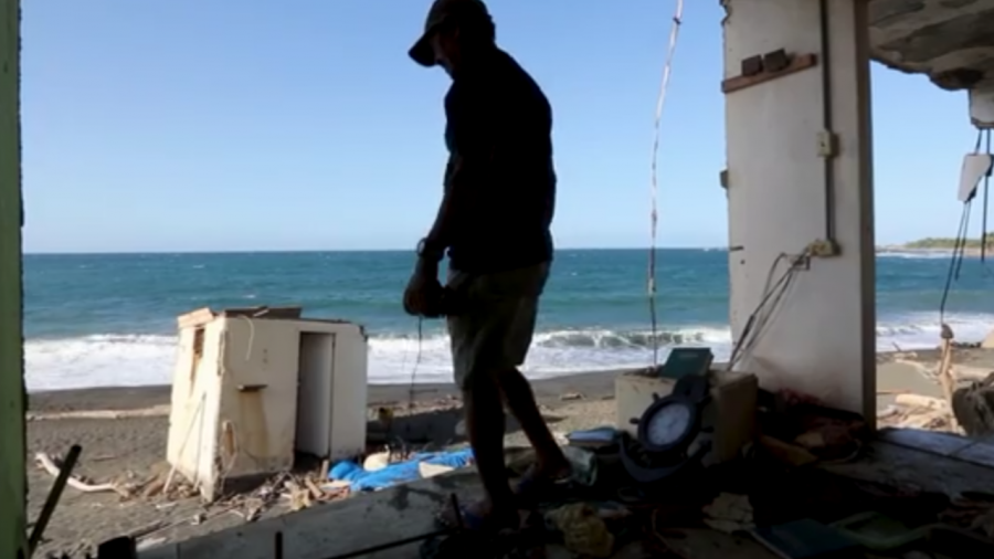 Alexander Gonzales picking through his torn up belongings after Hurricane Maria.