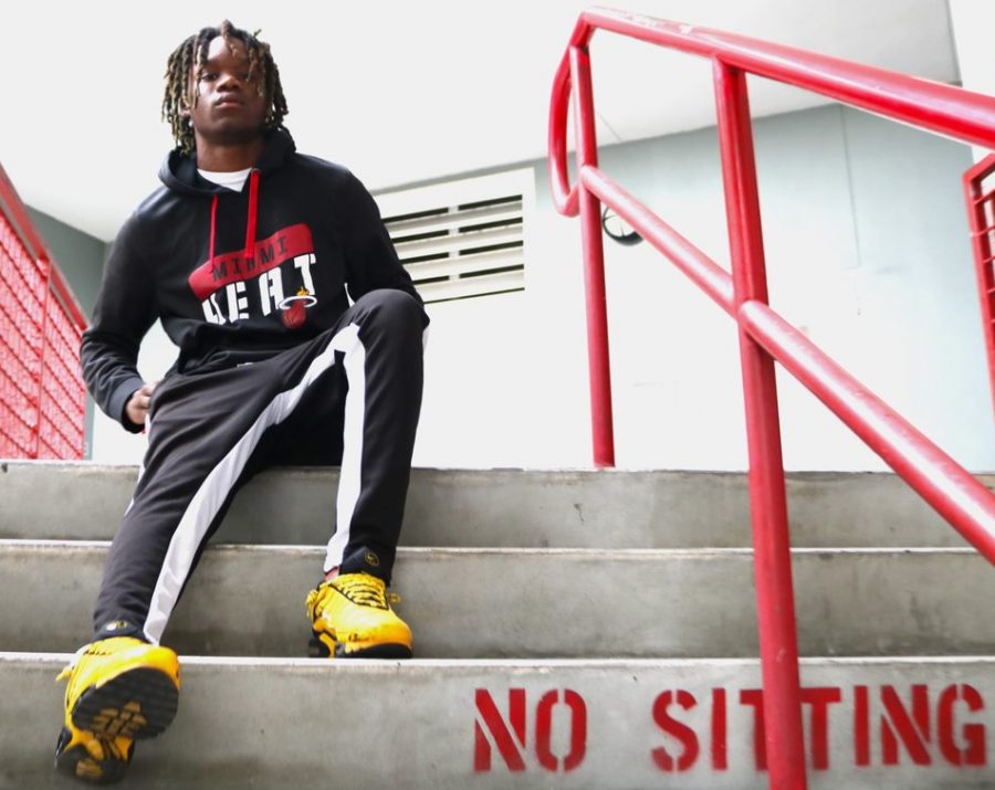 Rapper Frank Williams sitting on the steps of the 700 building.