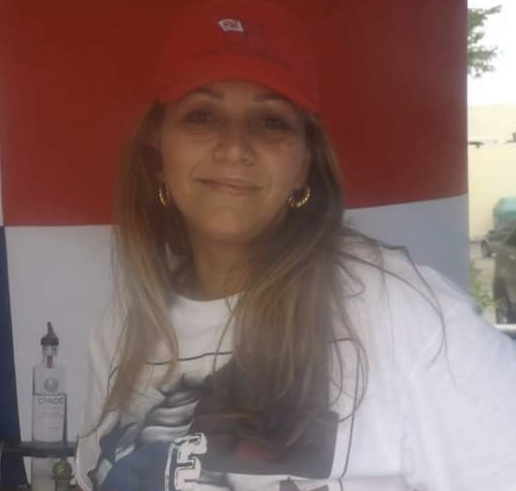 Isabel at a barbecue in front of the Panama flag.