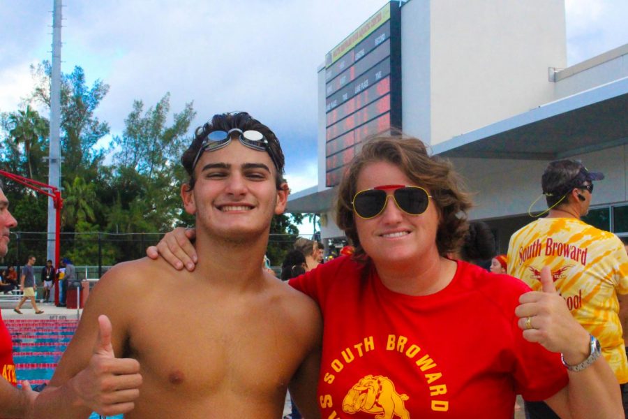 Logan moor (11th) and Mrs. Onett, give a thumbs up to the swimming competition in South Broward on October 10, 2019. The swimming coach and her student showed positive attitude towards the last home game they played against Western. 