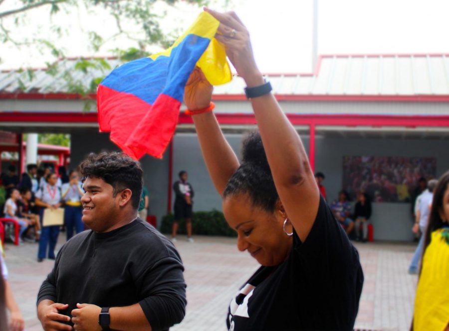 Jordy Aristizibal (12th) stands besides Mrs. Brown, who holds up the Colombian flag at the SBHS Hispanic Heritage Dance on October 10, 2019. SHBSs Principal held up the Hispanic flag up high, showing her support for latin population on SBHS. 