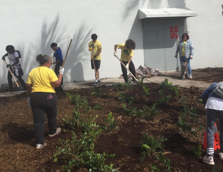 Students and other volunteers worked on adding some new plants near the front of the school. Helpers handled fresh soil and planted with the help of adults.