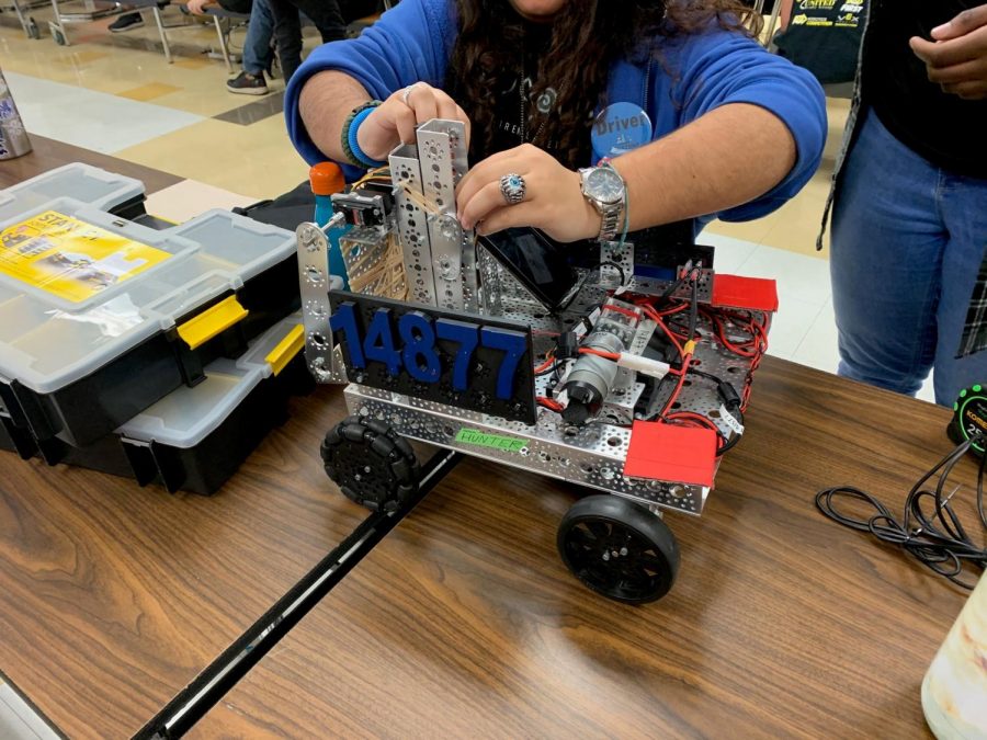 Head of Hardware for team 14877 Nancy Herrera fixing loose ends on their robot.