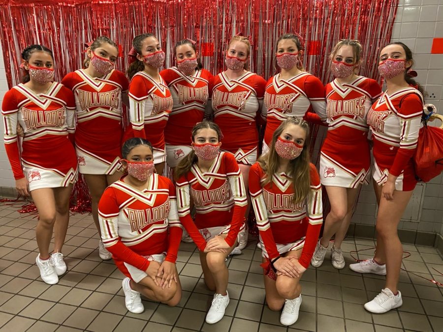 The South Broward cheer team posing and taking a picture after decorating the boys locker room for their game against Hallendale