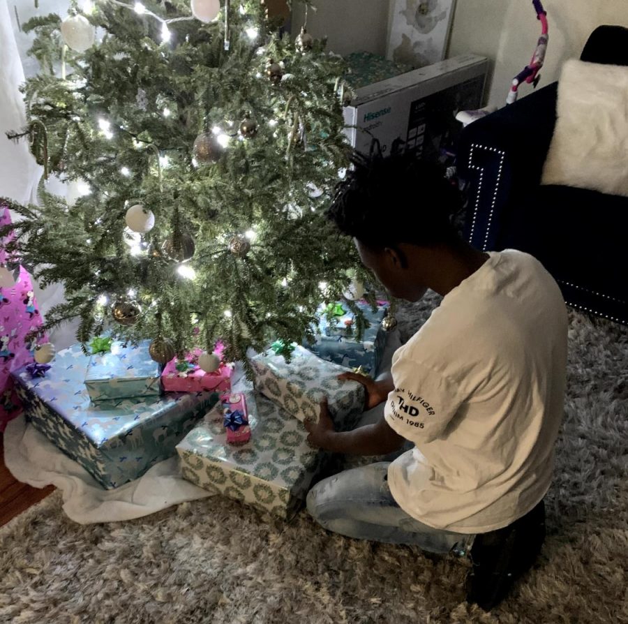 16 year-old, Calvin Lee is placing Christmas gifts under his tree.