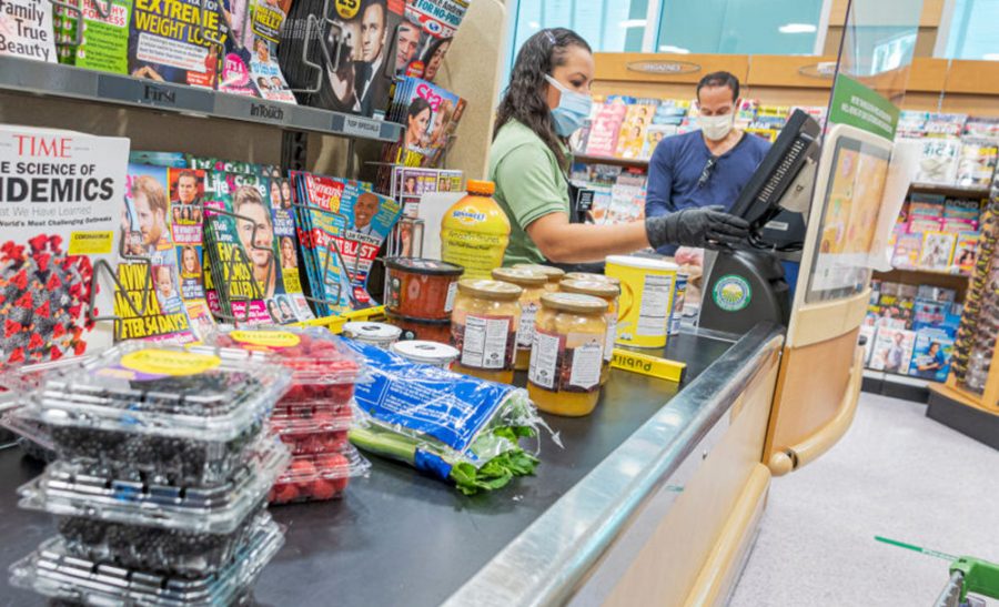  Publix cashier and customer wearing face masks and gloves, for protection against the virus.