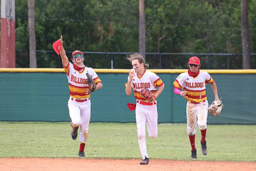 Max Marcus (middle) takes a sniff of the ball after making a game-saving catch on the warning track of the District Semi-Final on April 27th, 2021. To his right is center fielder Luke Valenchis and shortstop Alex Lopez.
