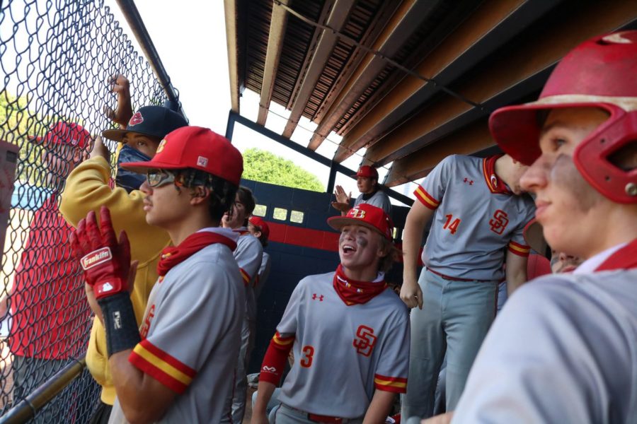 Tyler Ochs and Alex Lopez cheer on from the dugout during the Bulldogs varsity game against Chaminade-Madonna on March 17th, 2021.
