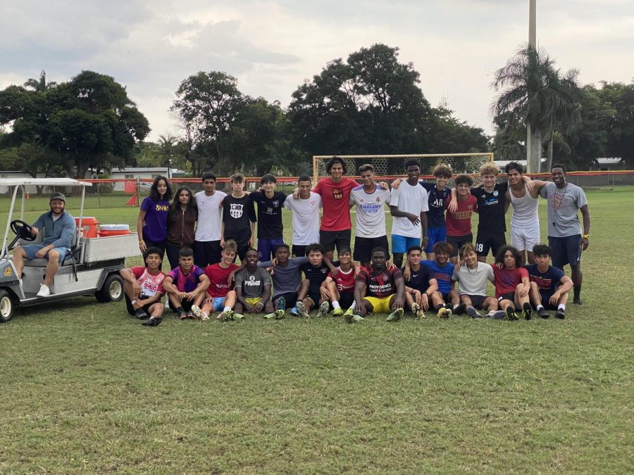 The players, coach, manager, and trainer pose for a team photo.