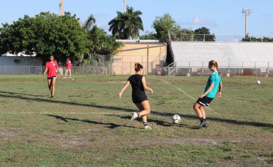 Two girls from the soccer team practicing at there home field.