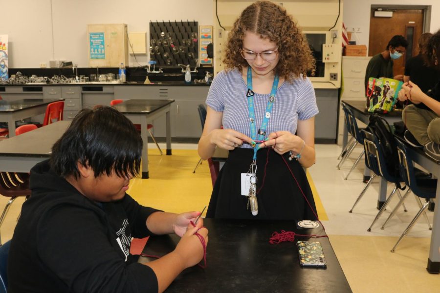 SBHS junior Emily Shouman shows a sophomore how to crochet. Shouman started Loops of Love this spring to teach students how to crochet.