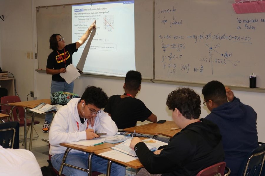 Setosta explains a math equation to the students.