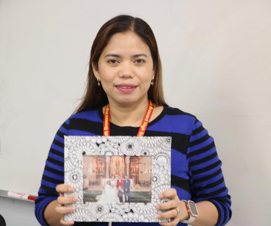 Ms. Alegrado holds up a picture of her family from back in the Philippines. 
