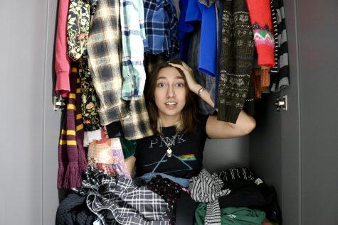 Isabella Piccolo sits crisscross inside a closet, posing with Shein bought clothes all around her.