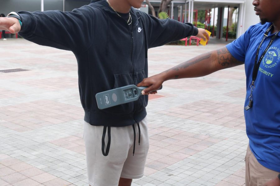 A SBHS security guard shows how he scans a student for weapons in the high school court yard. Broward County School Board passed a measure for surprise searches using hand-held metal detectors. 