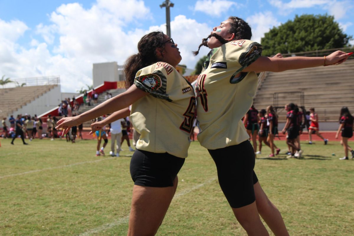 Sarah and Angela are both Juniors at SBHS; they just won against the seniors in the PowerPuff Game and are celebrating by giving each other a very well-deserved chest bump.