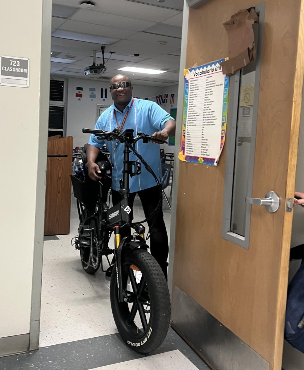 Mr.+Lloyd+McFarlane+poses+with+his+electric+bike.+He+has+been+riding+to+school+for+the+past+10+years+that+he+has+worked+at+SBHS.