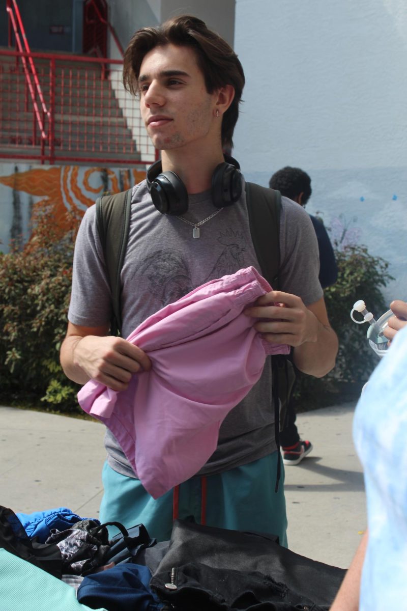 SBHS senior, Ben Aguerre, goes through the first ever SBHS Social Studies Honors Society thrift store, looks at pink shorts.