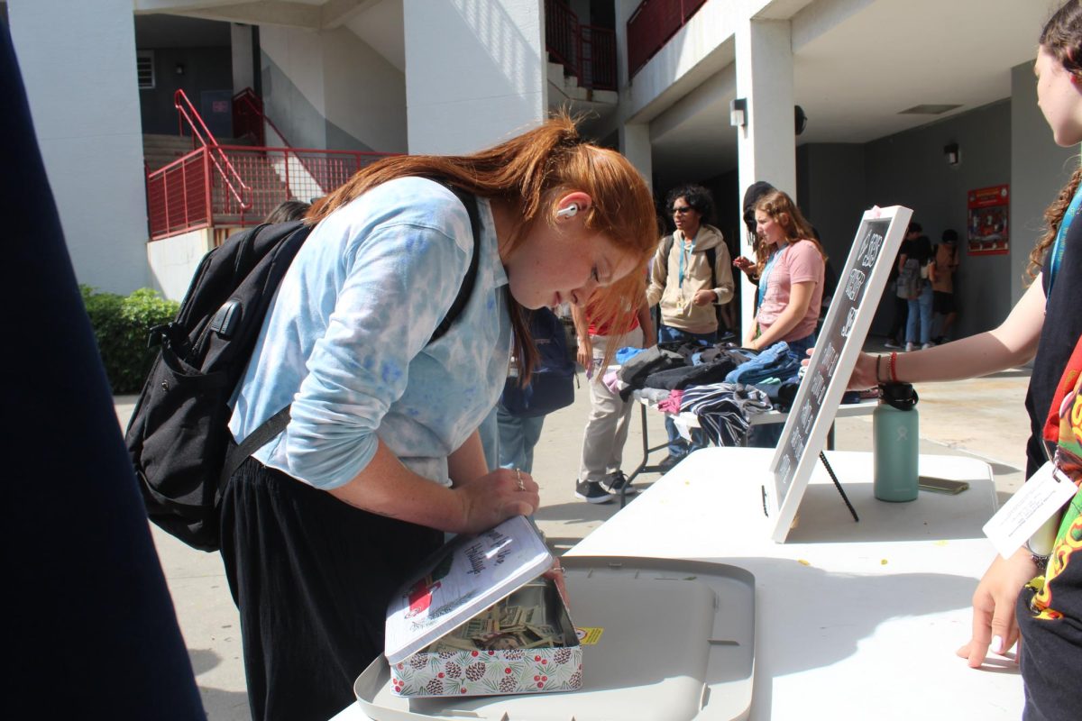 SBHS senior, Casey Carlson, collects money from the sale of donated clothing during the first every SBHS Social Studies Honors Society thrift store. Beginning Feb. 12 the club sold clothing, purses and other items during A and B lunches that SBHS students had donated for sale. 