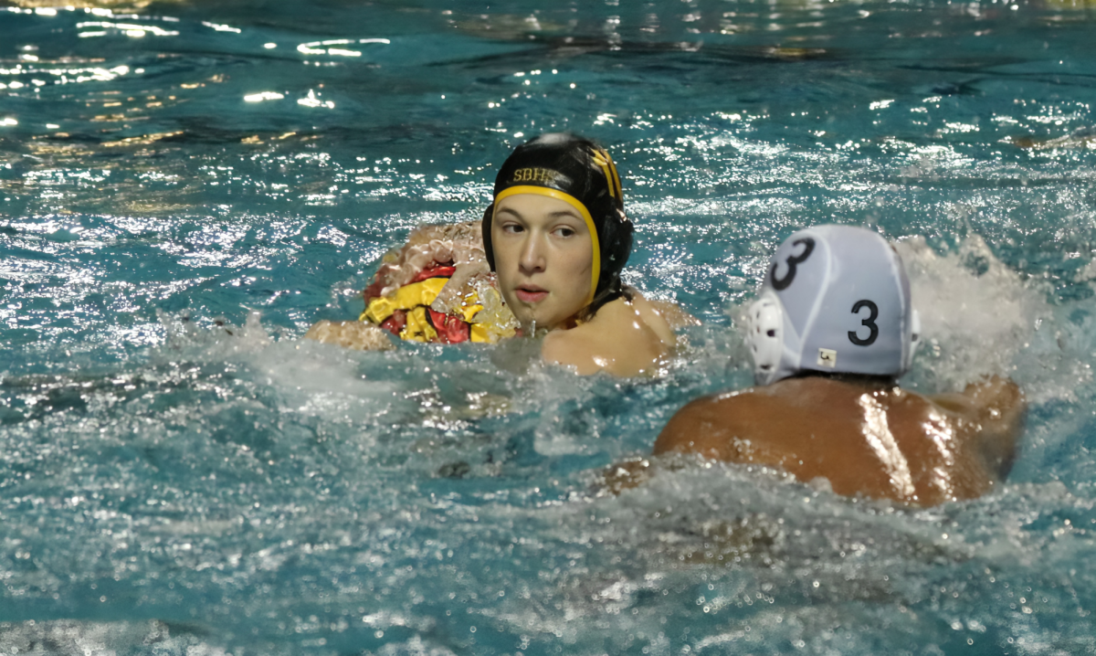 Senior Bryan Porter diligently defends the ball, denying Cypress Bay possession of the ball.