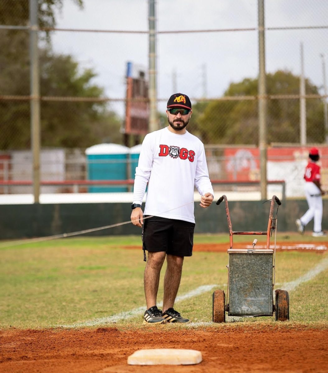 Coach Nino is helping run the boys varsity baseballs practice.