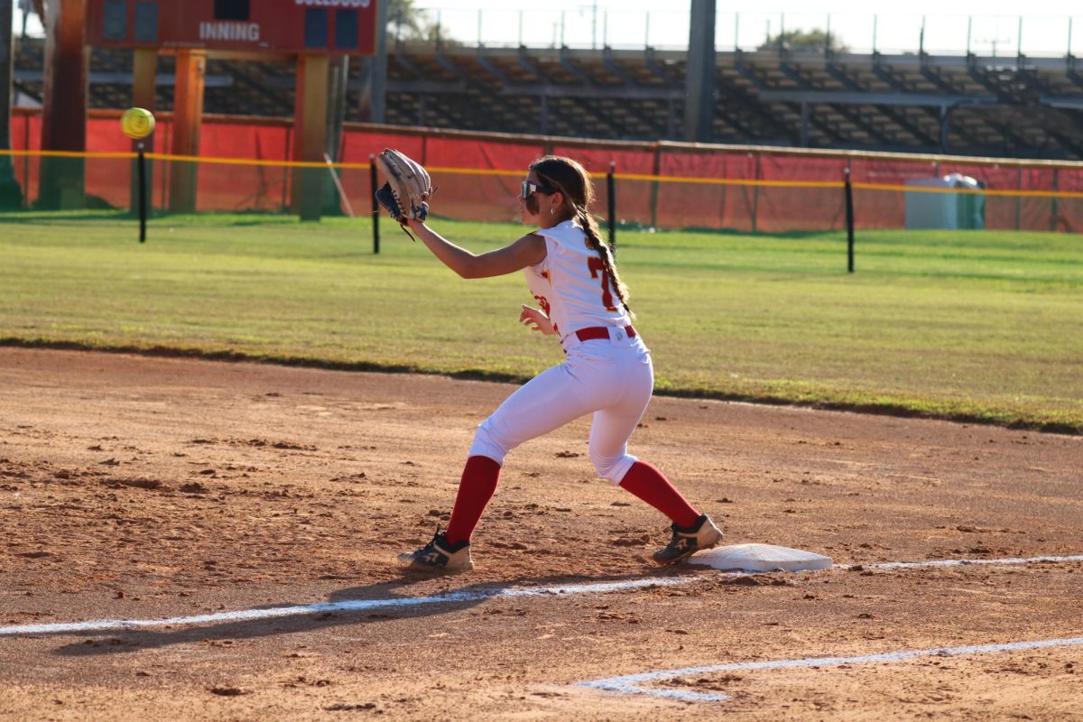 Freshman powerhouse Angelina Romero extends her reach for the catch, securing the out at first base with precision.