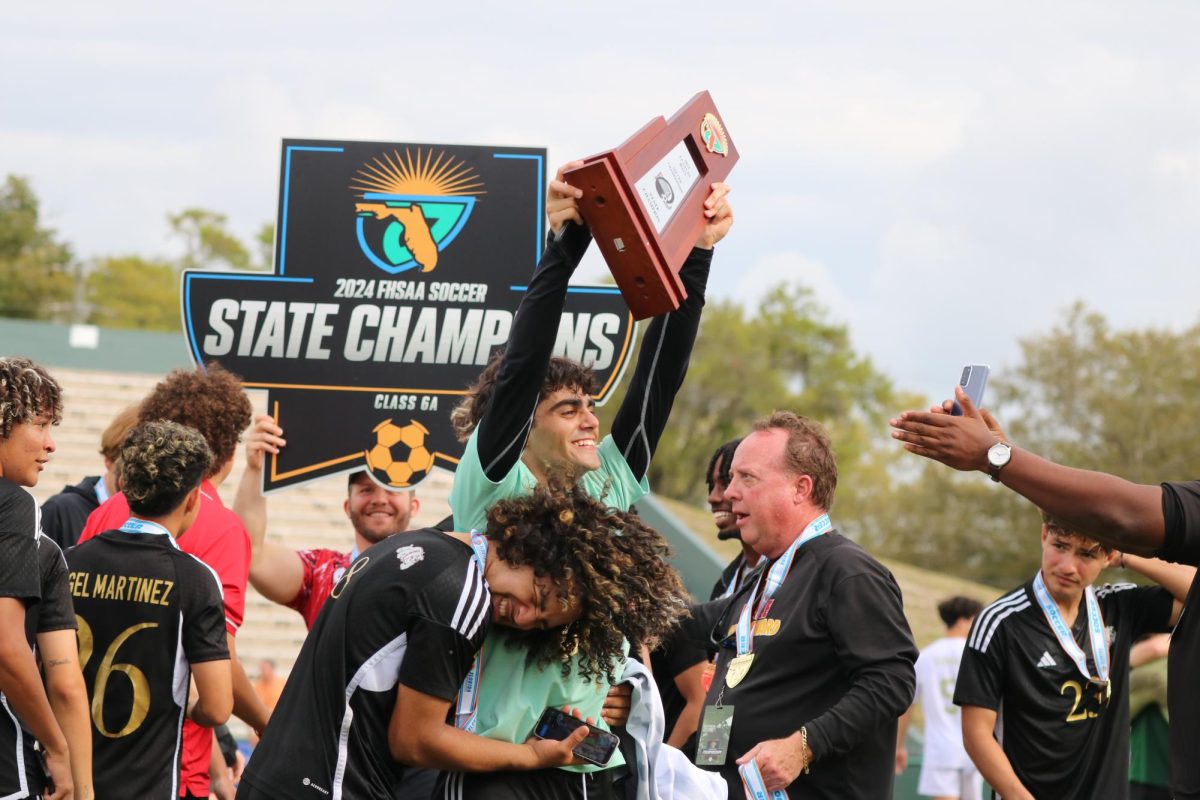 SBHS goalie Ivan Fernandez gets a celebratory hug from fellow teammate Mario Garcia as he holds the state championship trophy above his head in victory. The boys soccer team made school history with their first-ever FHSAA Division 6A state title. 