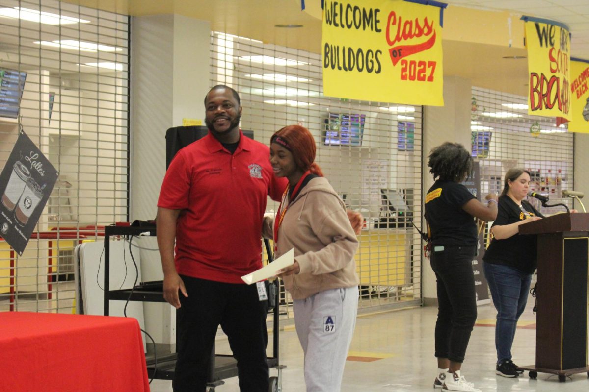 Mr. Francois greeting his South Broward senior student Heaven Mcclam with a hug congratulating her for getting honor roll.