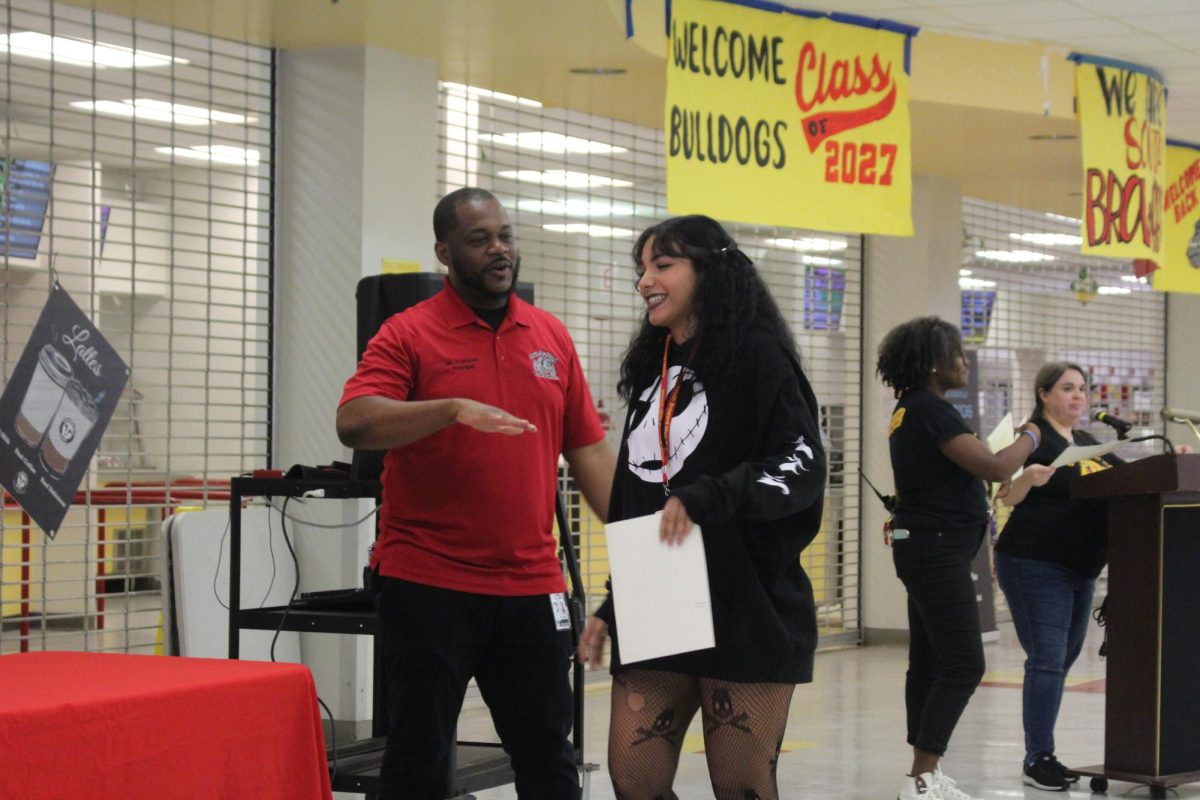 Mr. Francois gets happy for his senior student Angelyssa Medina getting honor roll as he interacts with her, making her smile.