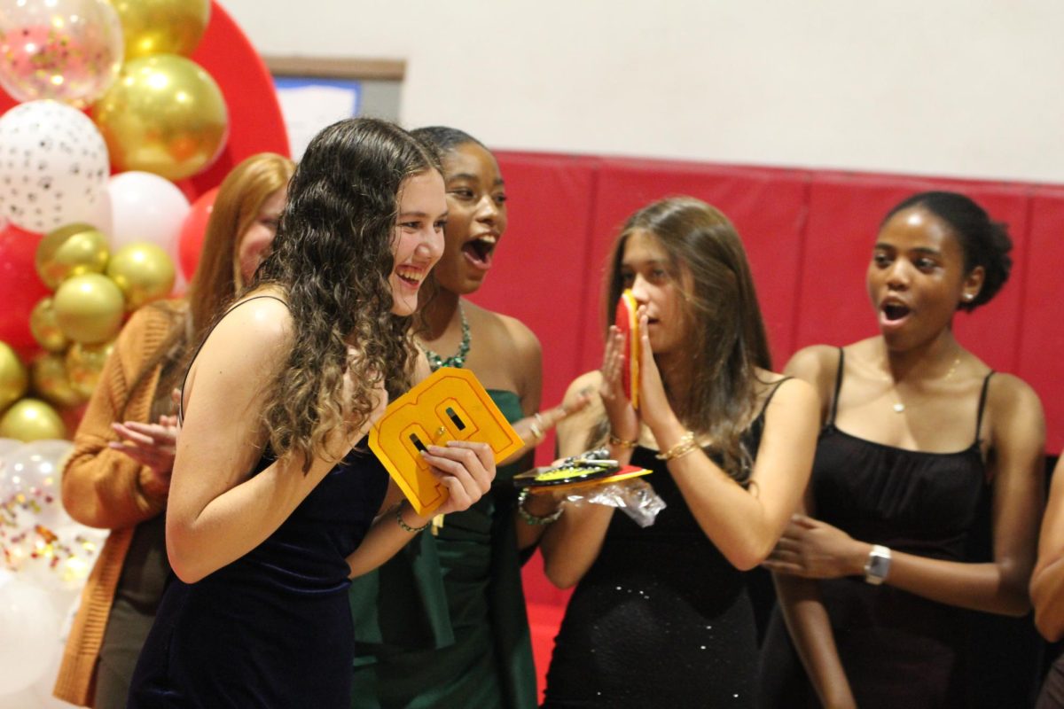 Softball team congratulates Isabel Wellins for her award as MVP.