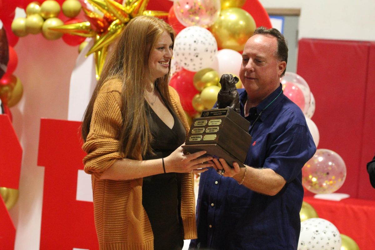 Casey Carlson receives the Bulldog Award from Coach Boomer, after congratulating her with a hug.