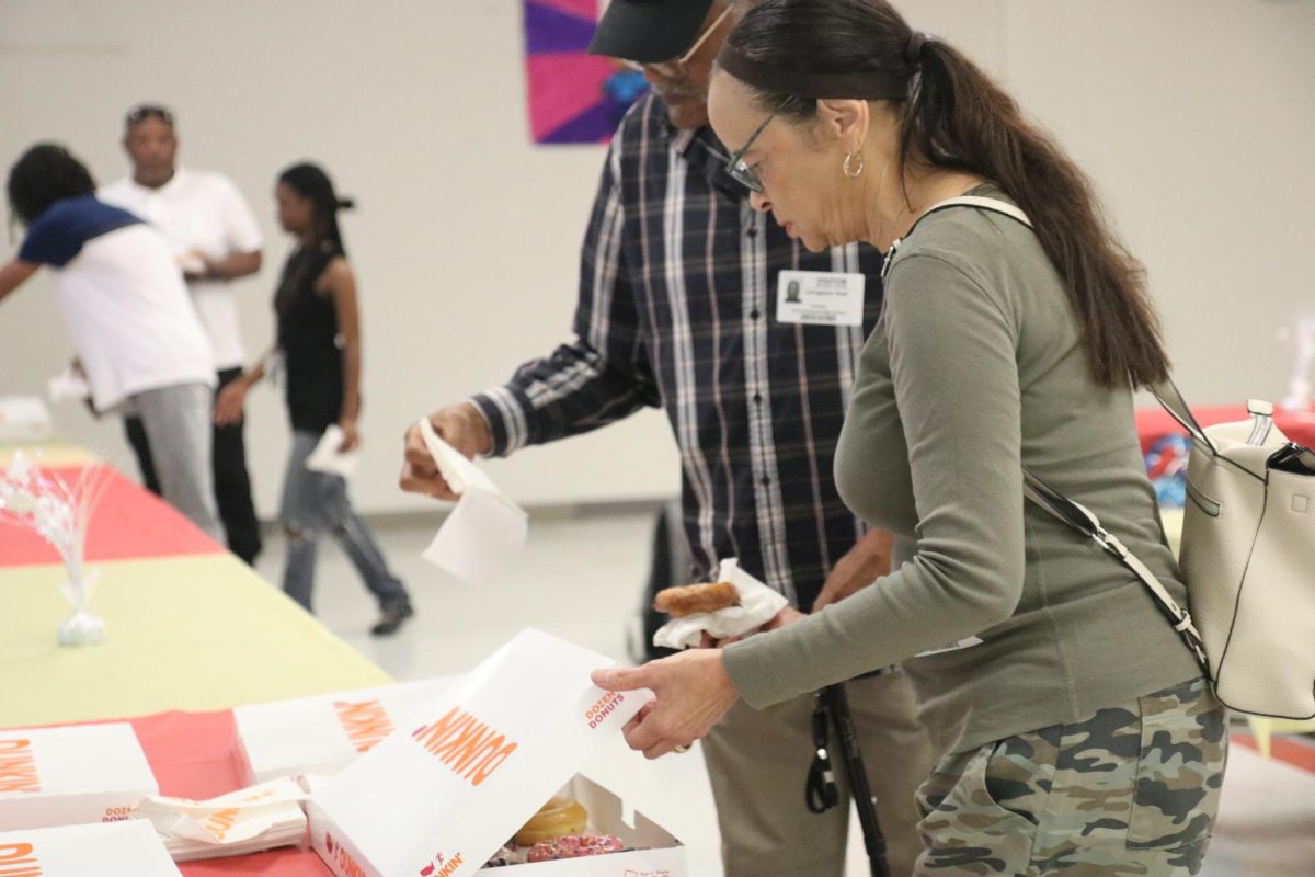 Both grandparents Mrs. and Mr. Deal grab some delicious delight of donuts to get ready to take a seat with their grandchild and enjoy their breakfast while they wait for the drama students to preform.