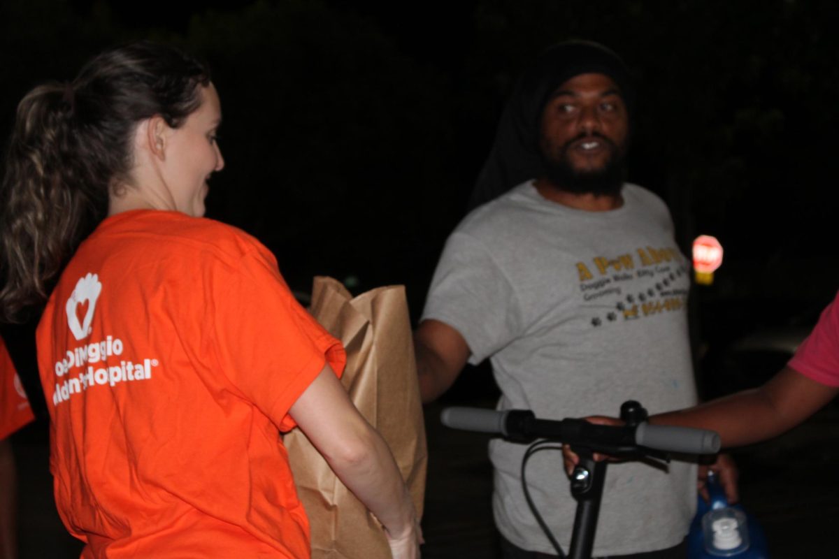 Ms. Cierra, a sponsor of SGA at SBHS, assists in providing essential supplies and food to a local family during the annual harvest drive.