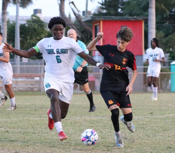 Senior midfielder Julian Cabrera charges toward the ball with unrelenting determination, locked in a fierce battle against a Coral Glades defender.