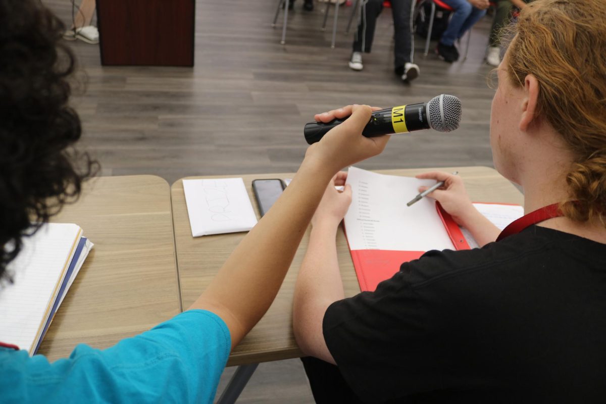 SBHS Junior Benjamin Soren reading the words aloud to contestants. 