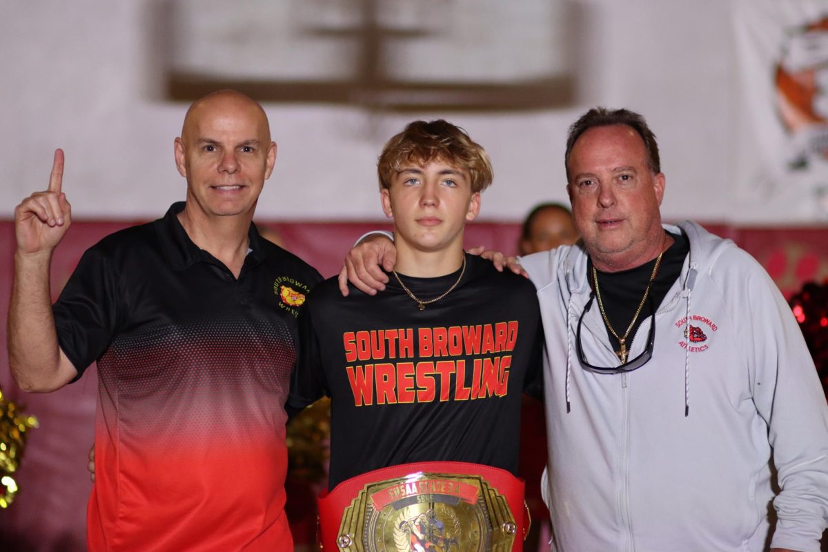 Flanked by SBHS Wresting Coach Threlkeld Major and SBHS Athletic Director Lee "Boomer" Bray, SBHS freshman Illia Kyryianenko poses for a photo with the FHSAA Championship Wresting Belt. Kyryianenko was the first SBHS student to win a state championship in 15 years.