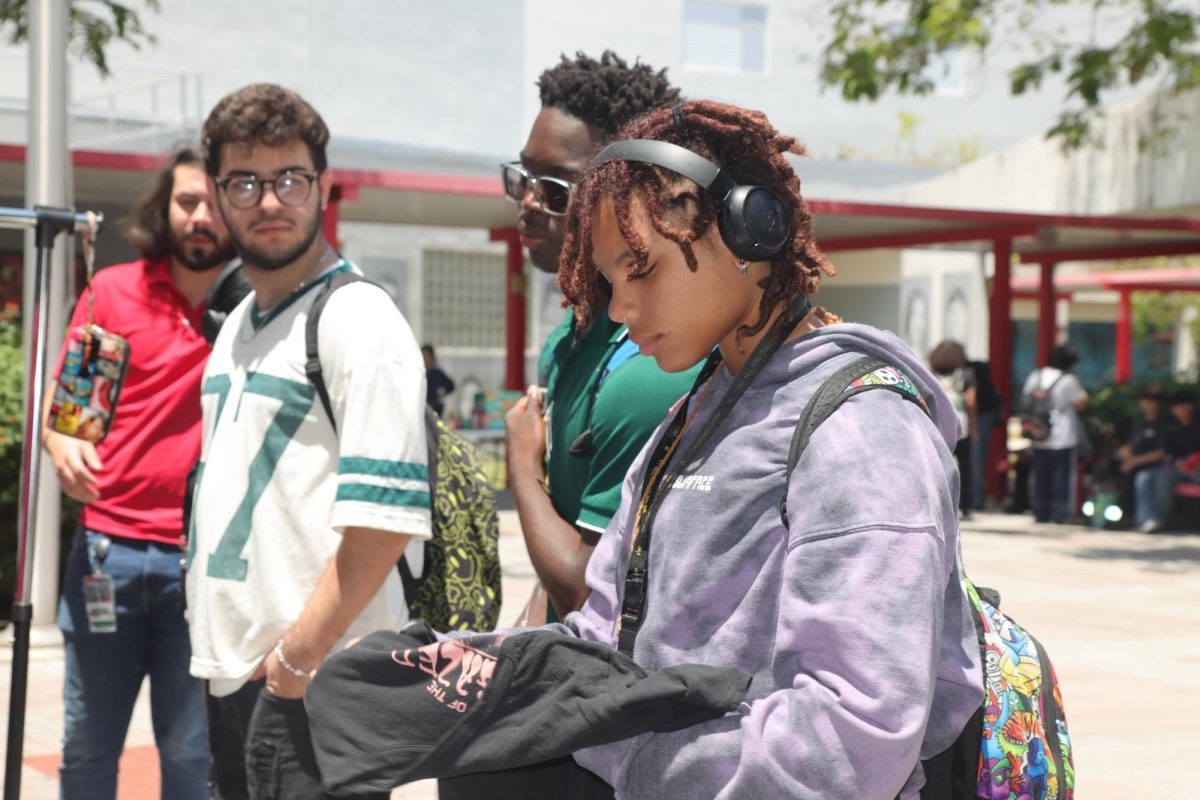Sophomore Jaylene Hall browses through a pile of donated clothes during the SBHS thrift store event, pausing to check out a black graphic t-shirt.