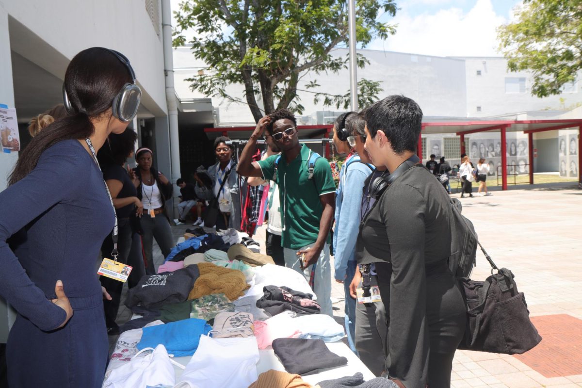 Students line up eagerly for the second annual school thrift store, ready to sift through the piles of clothes in hopes of finding hidden treasures.