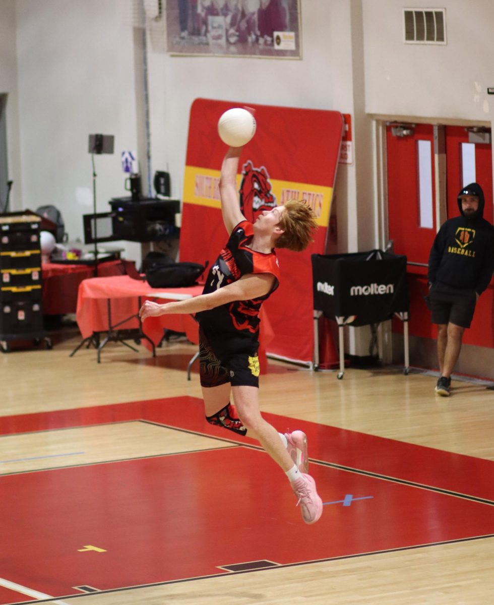 Junior Nathan Carlson launches into the air for a stunning serve, landing a clean ace.