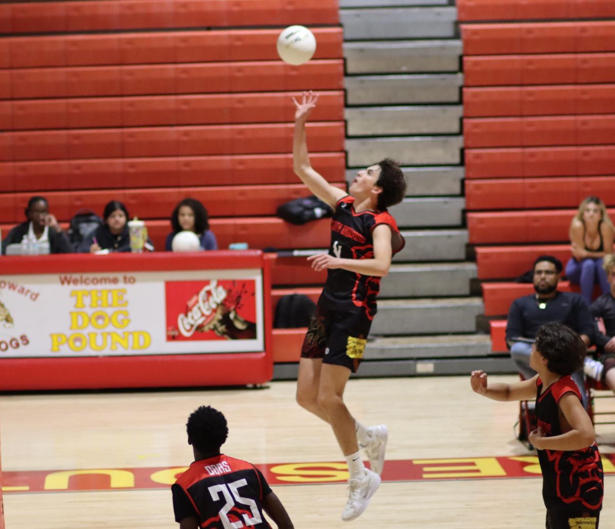 "SBHS Bulldog William Hill soars through the air, unleashing a spike against Flanagan's defense.