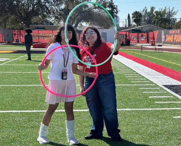 "Big smiles and sweet memories" on the football field during Love and service day on February 13,2026. Tow freshmen girls smiling while holding a hula hoops together.